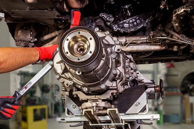 Mechanic Performing Transmission Repair on Vehicle in Garage